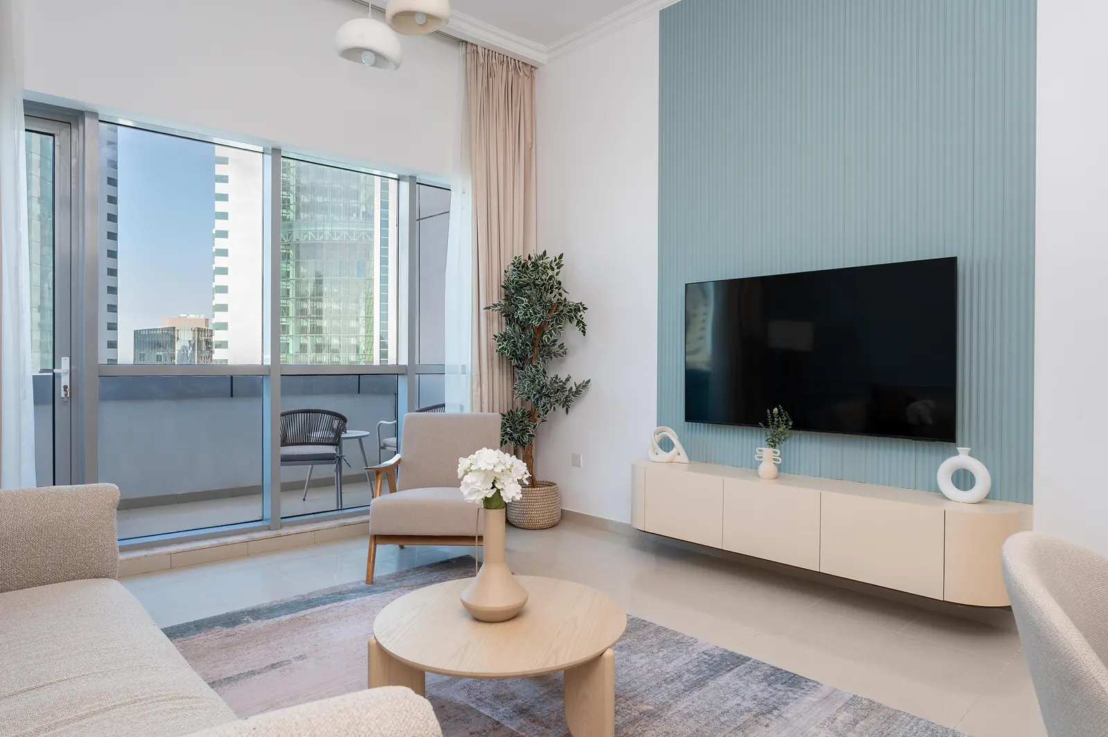 Fluted powder-blue TV wall with a floating cream console and a round coffee table
