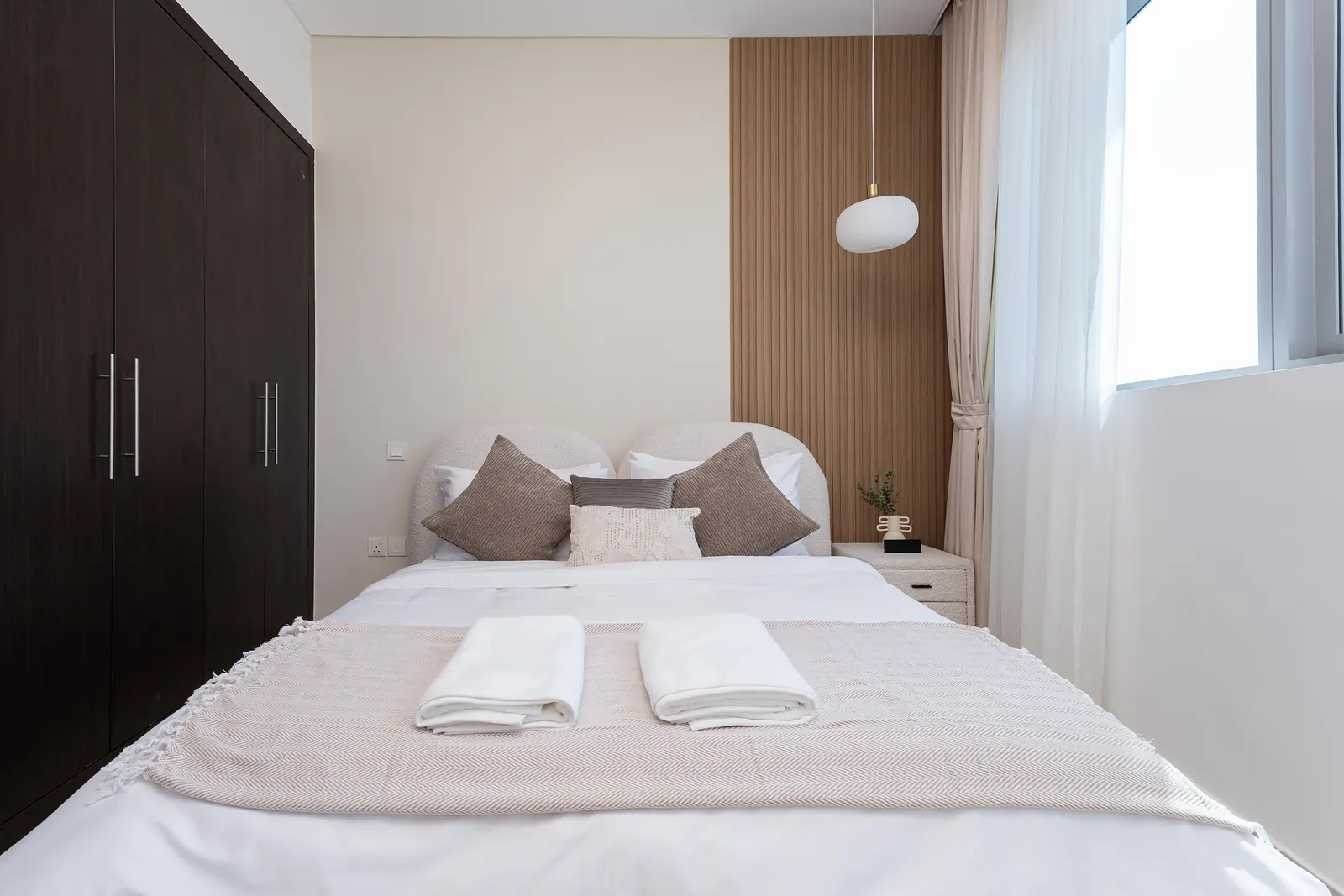 Second bedroom with a timber slatted panel beside the bed and a pendant light