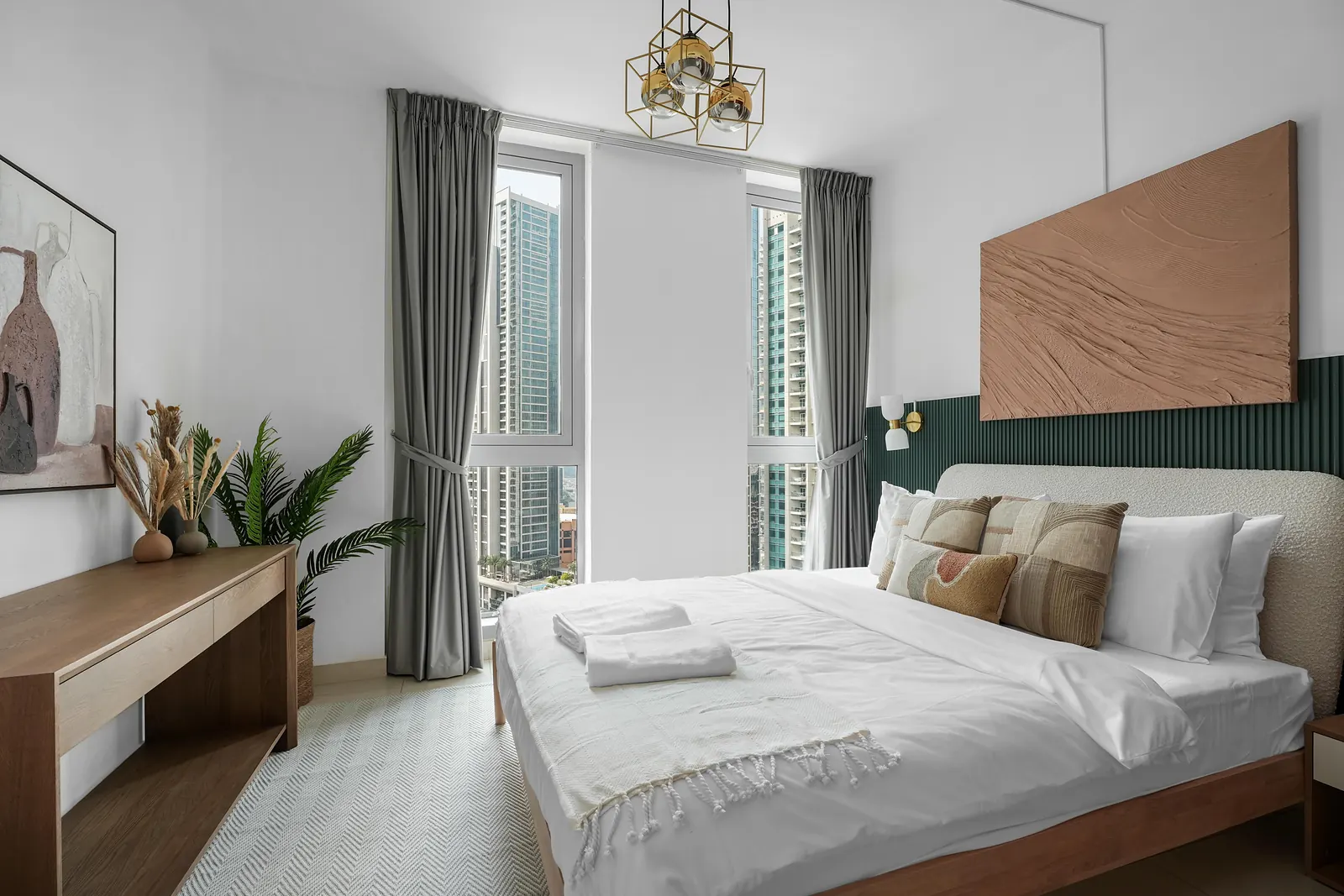 Master bedroom with a dark green fluted panel behind the bed and textured wall art
